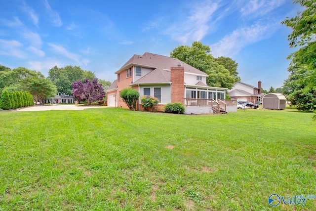 14850 Creek Ln, Athens, AL 35613 - rear view of property featuring a sunroom, a chimney, a yard, and brick siding