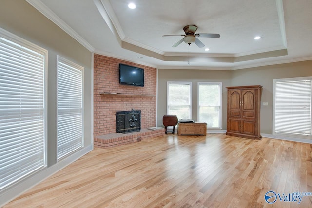 14850 Creek Ln, Athens, AL 35613 - living area featuring a tray ceiling, a fireplace, a ceiling fan, wood finished floors, and ornamental molding