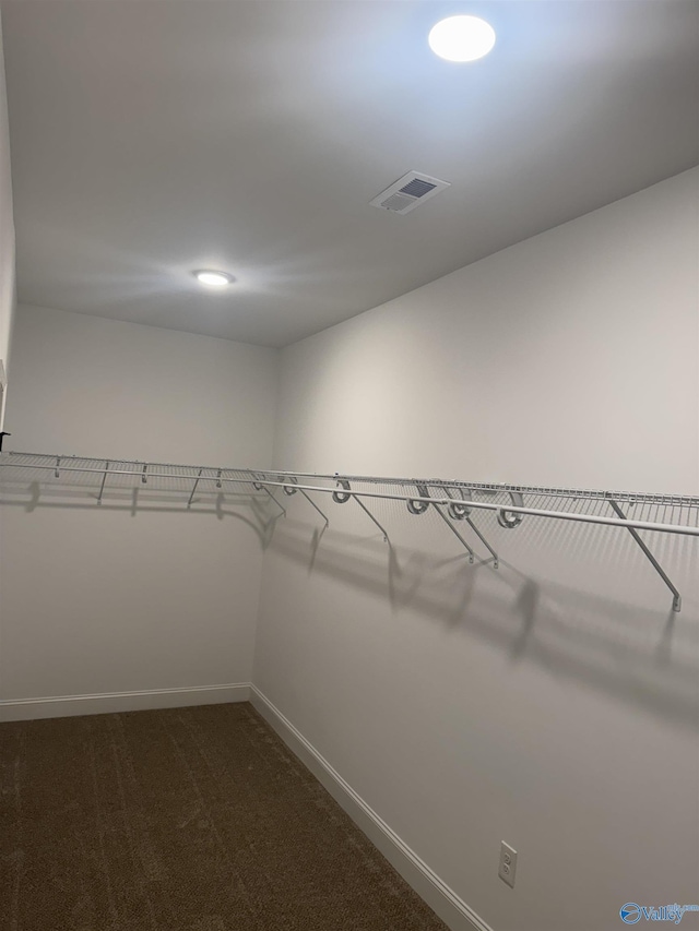 spacious closet featuring visible vents and dark carpet