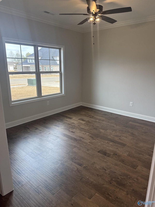 unfurnished room with dark wood finished floors, crown molding, and baseboards