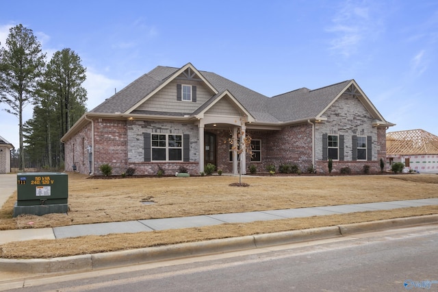 craftsman-style house with brick siding and roof with shingles