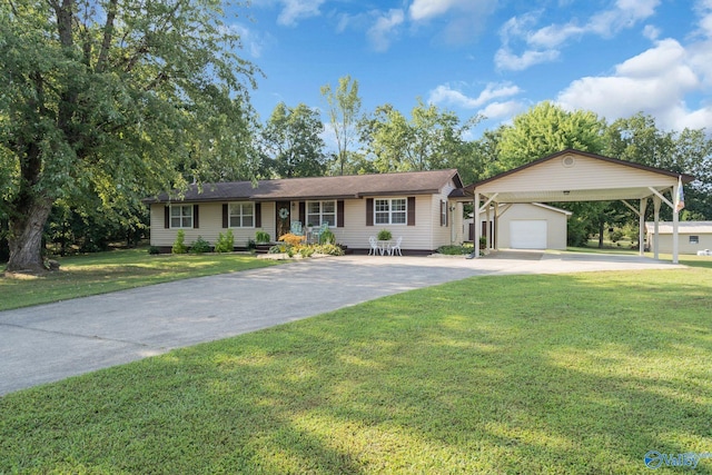 single story home with a carport, an outbuilding, a detached garage, and a front lawn