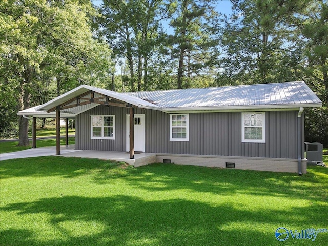 view of front of home featuring a front yard, a carport, and central air condition unit