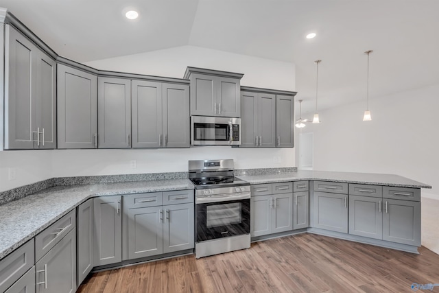 kitchen with gray cabinetry, light wood-style floors, appliances with stainless steel finishes, a peninsula, and vaulted ceiling