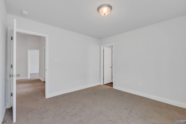 spare room featuring baseboards and carpet floors