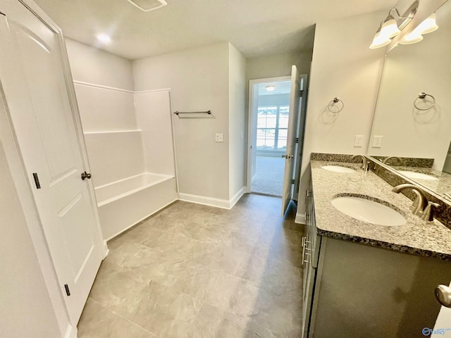 bathroom featuring a sink, baseboards, and double vanity