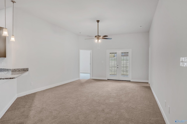 spare room featuring french doors, baseboards, ceiling fan, and carpet flooring