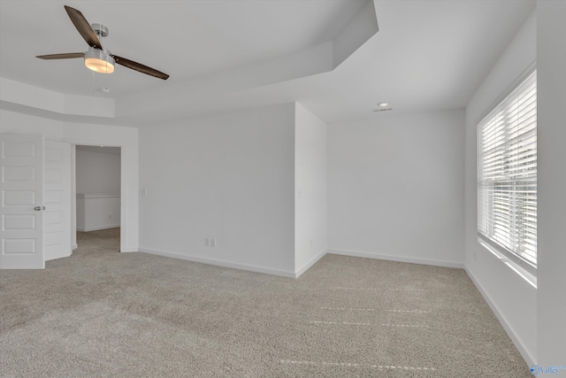 spare room featuring ceiling fan, plenty of natural light, and light colored carpet