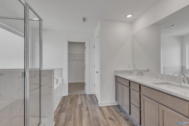 bathroom with vanity, wood-type flooring, and independent shower and bath