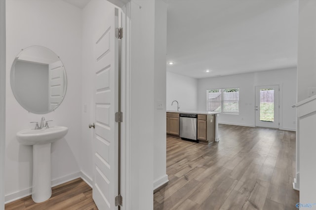 corridor with light hardwood / wood-style flooring and sink