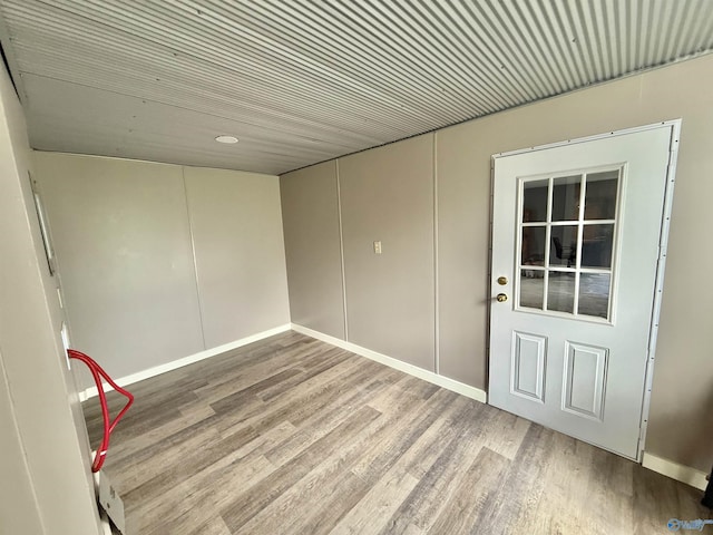 unfurnished room with baseboards and wood finished floors