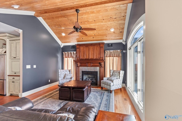 living area featuring plenty of natural light, wood ceiling, crown molding, and ceiling fan