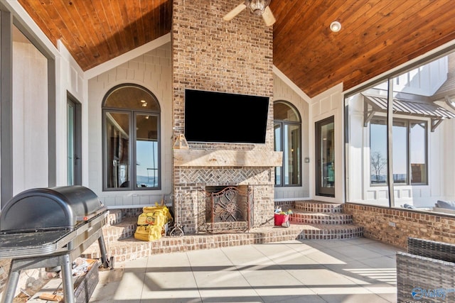 view of patio featuring a grill and an outdoor brick fireplace