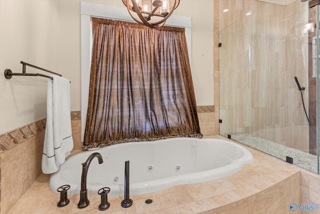 full bath featuring a jetted tub and an inviting chandelier