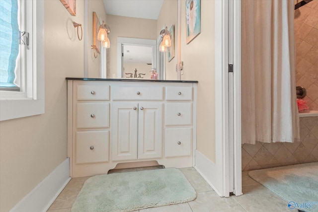 bathroom with tile patterned flooring, shower / bath combination with curtain, vanity, and baseboards