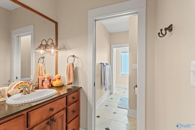 bathroom with tile patterned flooring, vanity, and baseboards