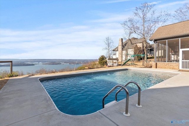 pool with a playground, a patio area, a water view, and a sunroom