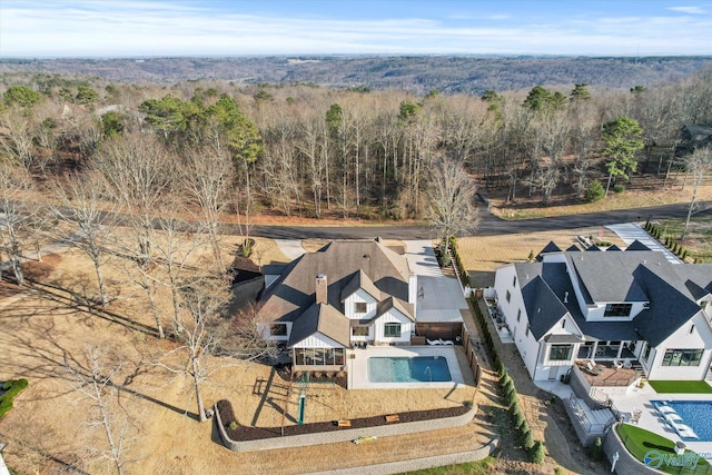 drone / aerial view featuring a wooded view