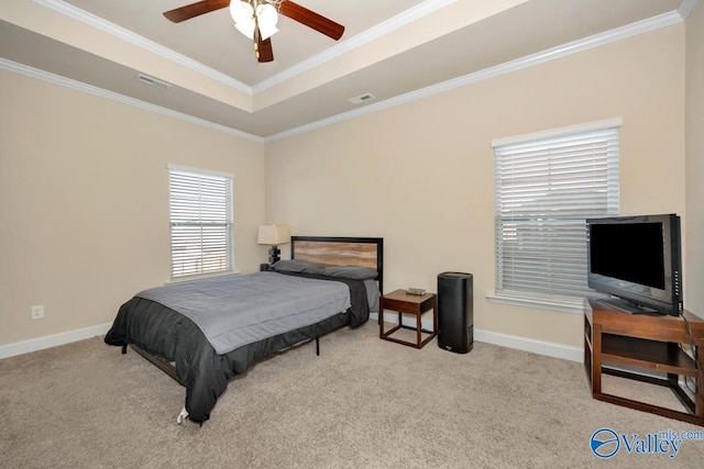 carpeted bedroom featuring baseboards, visible vents, a tray ceiling, and ornamental molding