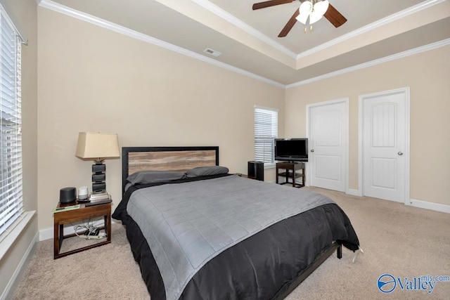 bedroom featuring light carpet, baseboards, visible vents, a raised ceiling, and ornamental molding