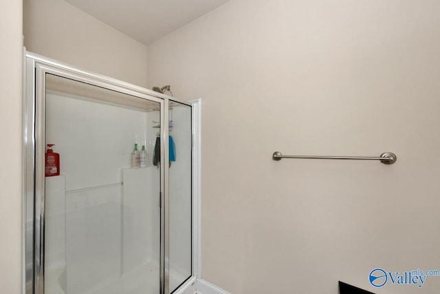 full bath with a shower stall and baseboards