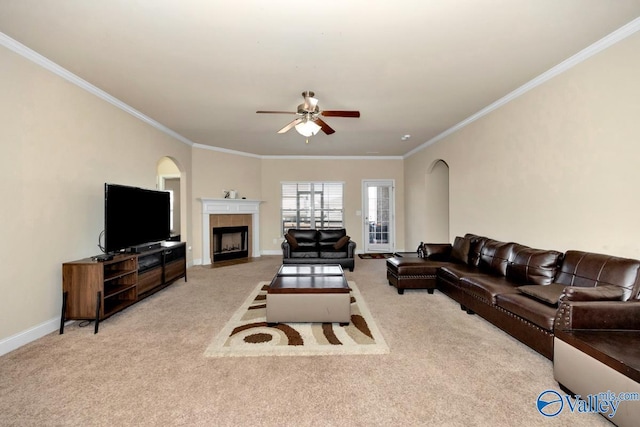 living area with ornamental molding, carpet, baseboards, and a tile fireplace