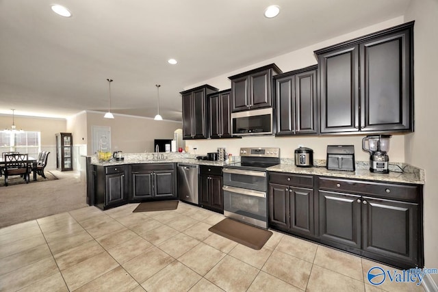 kitchen featuring light carpet, a peninsula, a sink, appliances with stainless steel finishes, and dark cabinetry