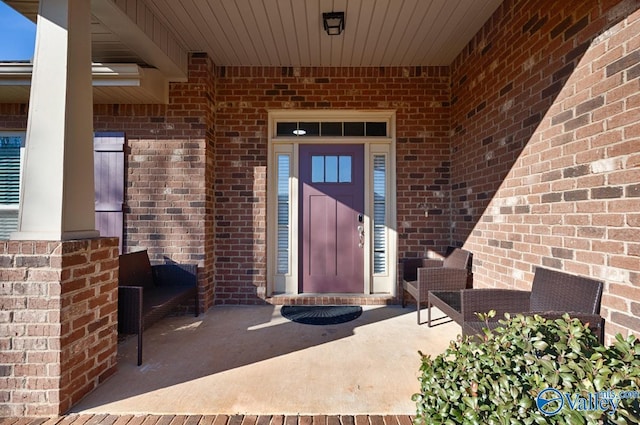 doorway to property featuring brick siding