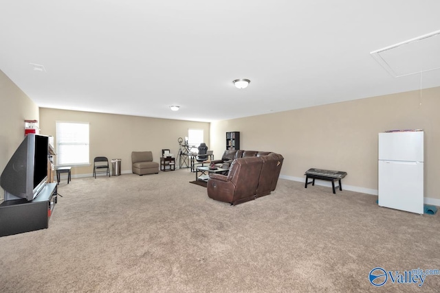 carpeted living room featuring attic access and baseboards