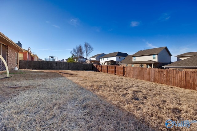 view of yard featuring a residential view and a fenced backyard