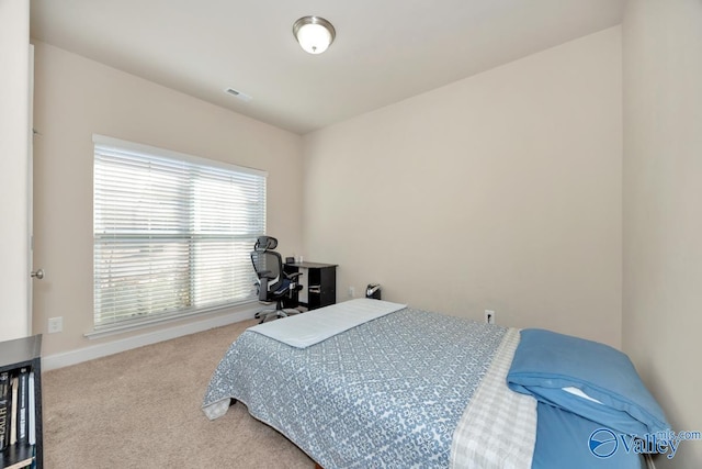 carpeted bedroom featuring visible vents and baseboards