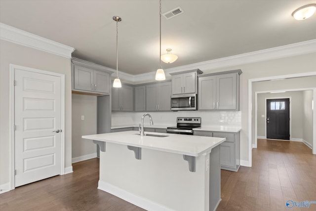 kitchen with sink, dark hardwood / wood-style floors, gray cabinets, an island with sink, and appliances with stainless steel finishes