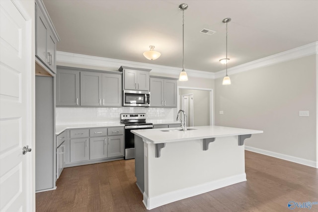 kitchen with crown molding, sink, dark hardwood / wood-style floors, appliances with stainless steel finishes, and decorative light fixtures