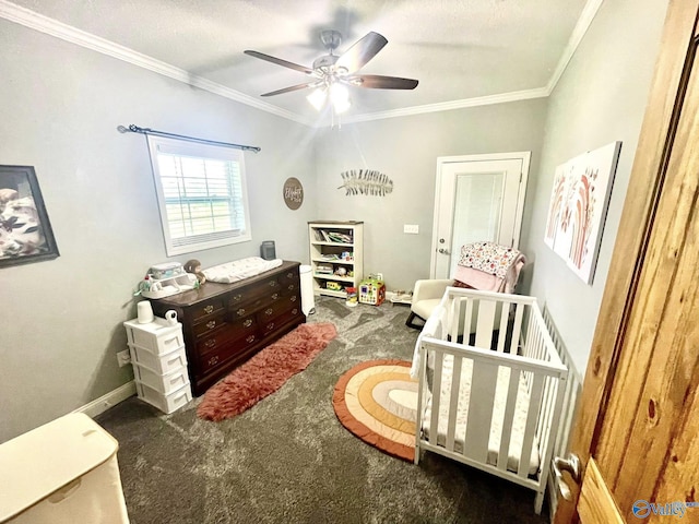 carpeted bedroom featuring a crib, ornamental molding, baseboards, and a ceiling fan