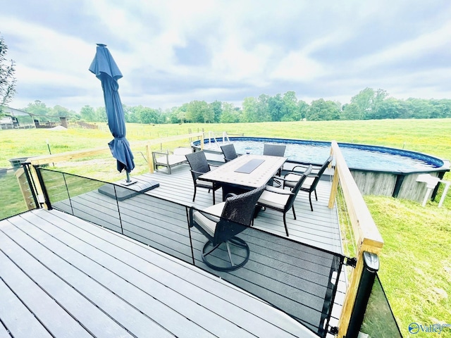 deck featuring a lawn and outdoor dining area