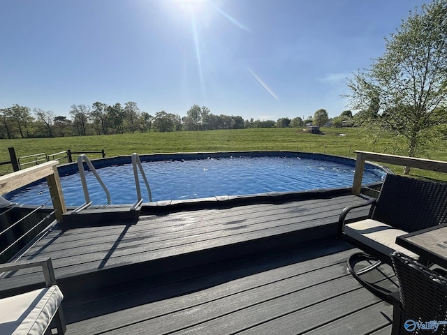 view of pool with a yard and a wooden deck