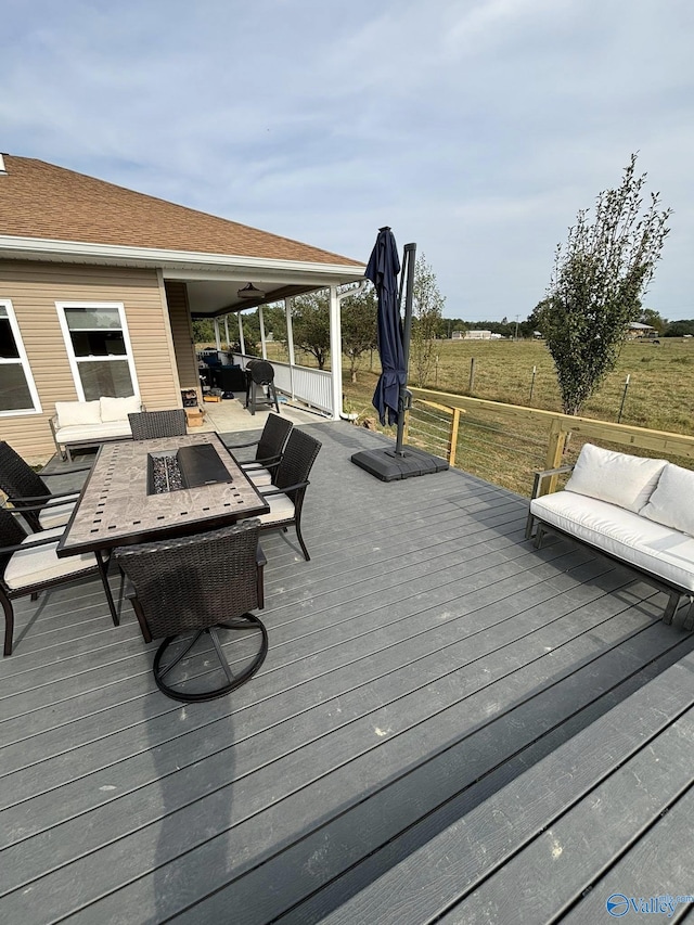 wooden terrace featuring an outdoor living space with a fire pit