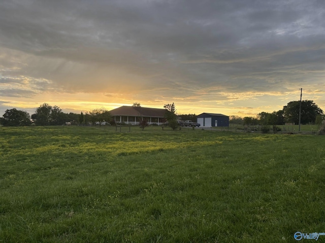 view of yard with an outbuilding, a rural view, and a detached garage