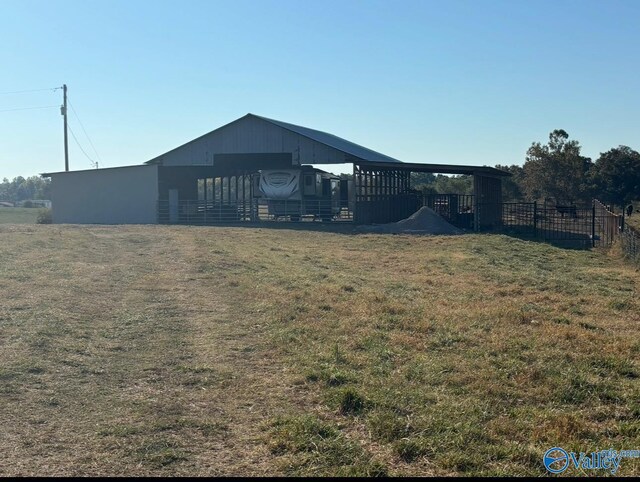 exterior space featuring a pole building, fence, and an outbuilding