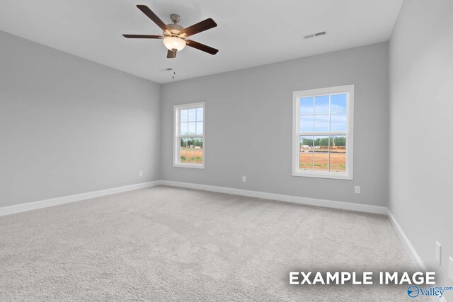 carpeted spare room featuring ceiling fan