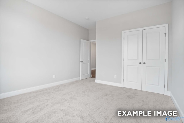 unfurnished bedroom featuring light colored carpet and a closet