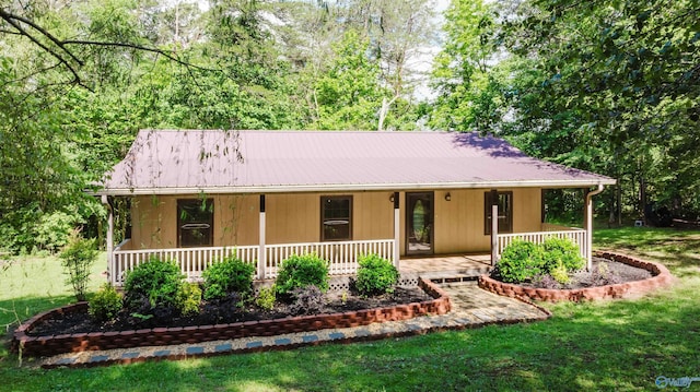 view of front of home with metal roof, a porch, and a front yard