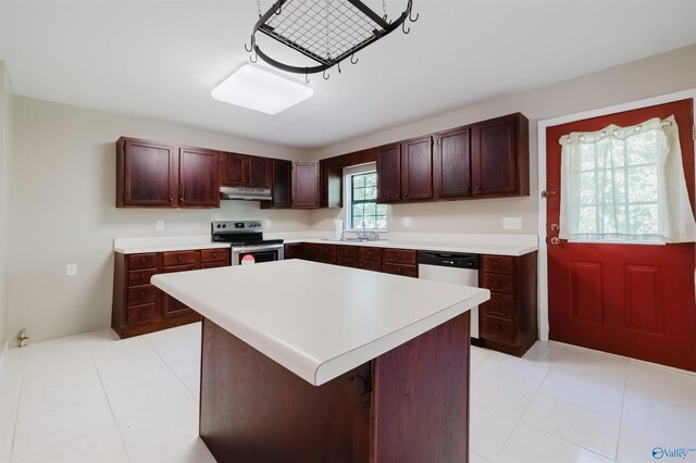 kitchen with appliances with stainless steel finishes, light tile patterned floors, sink, and a kitchen island