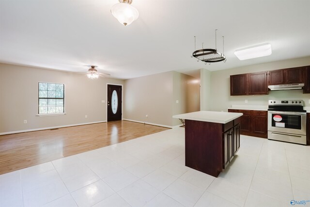 kitchen with light hardwood / wood-style flooring, dark brown cabinets, a center island, electric range, and ceiling fan