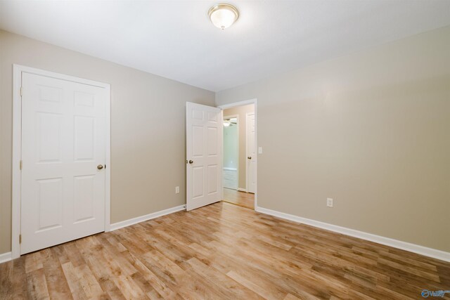 unfurnished bedroom featuring light hardwood / wood-style flooring and a closet