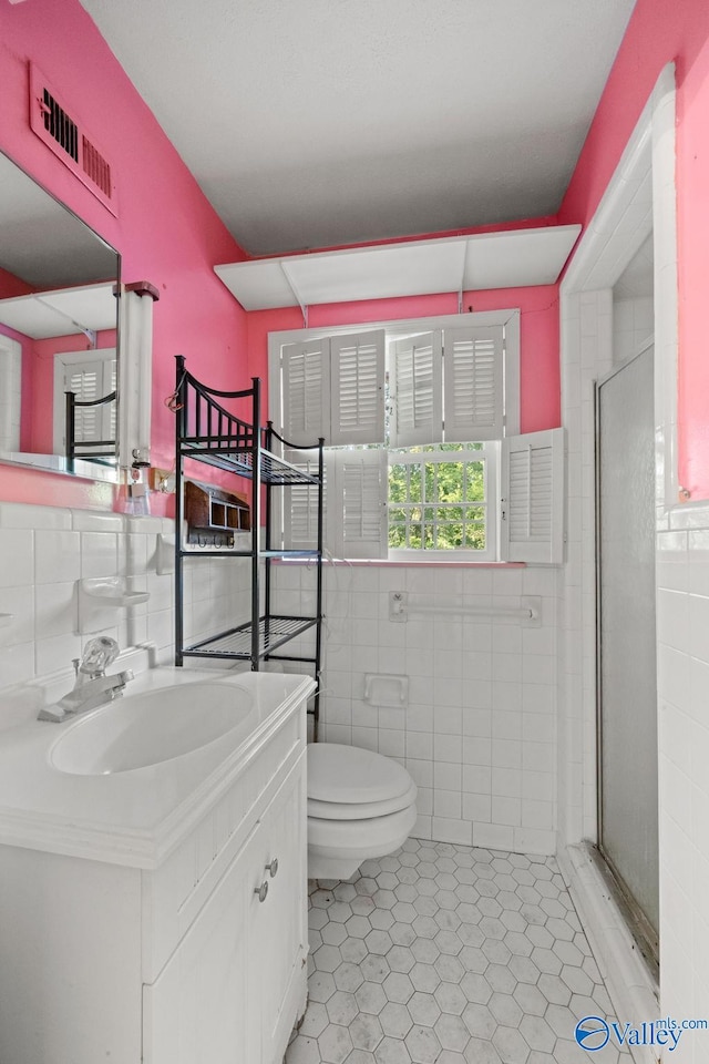 bathroom featuring tile walls, vanity, and toilet