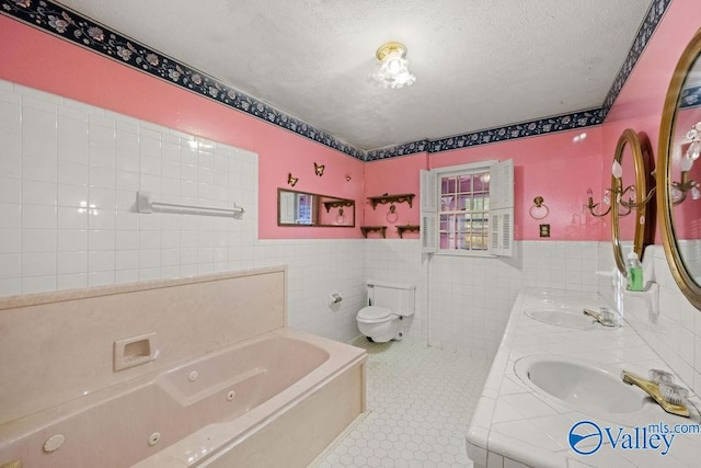 bathroom featuring a bathing tub, a textured ceiling, tile walls, toilet, and vanity