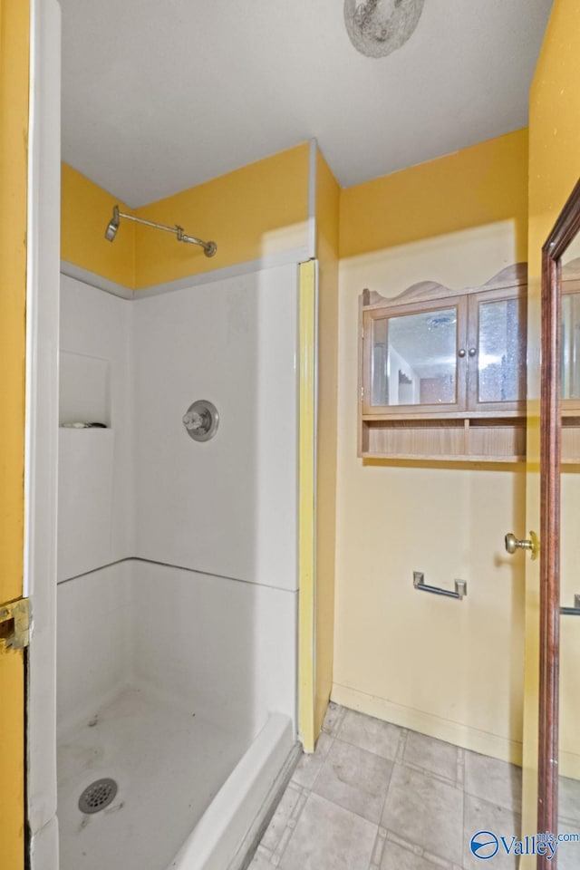 bathroom featuring walk in shower and tile patterned flooring