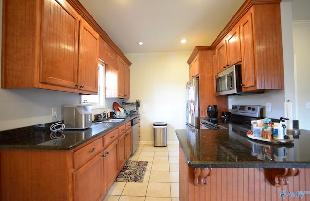 302 Meredith Dr, Muscle Shoals, AL 35661 - kitchen featuring stainless steel appliances, brown cabinetry, ornamental molding, a peninsula, and light tile patterned flooring