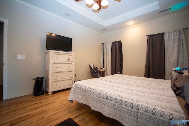 302 Meredith Dr, Muscle Shoals, AL 35661 - bedroom featuring a tray ceiling, light wood-style floors, ornamental molding, and a ceiling fan